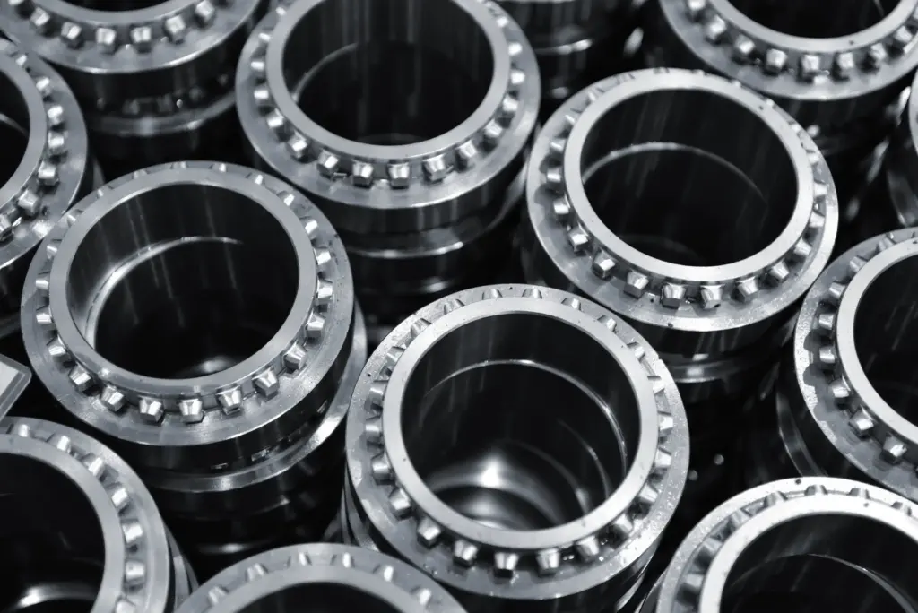 Close-up of stacked metal flange bearings with bolt holes around the rims