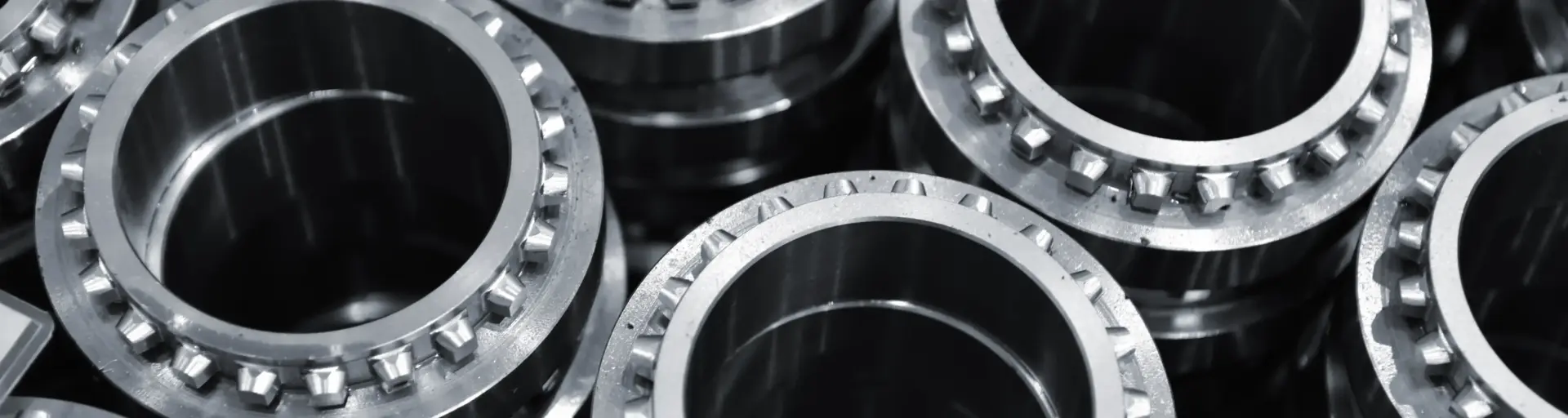 Close-up of stacked metal flange bearings with bolt holes around the rims